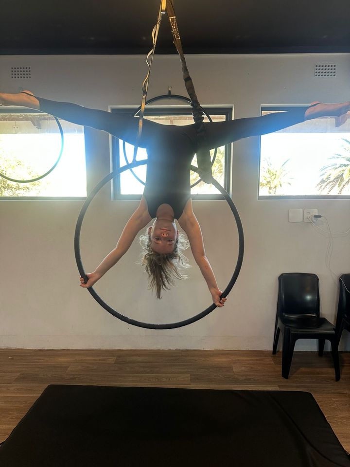 Aerial artist inverted in the hoop in the studio