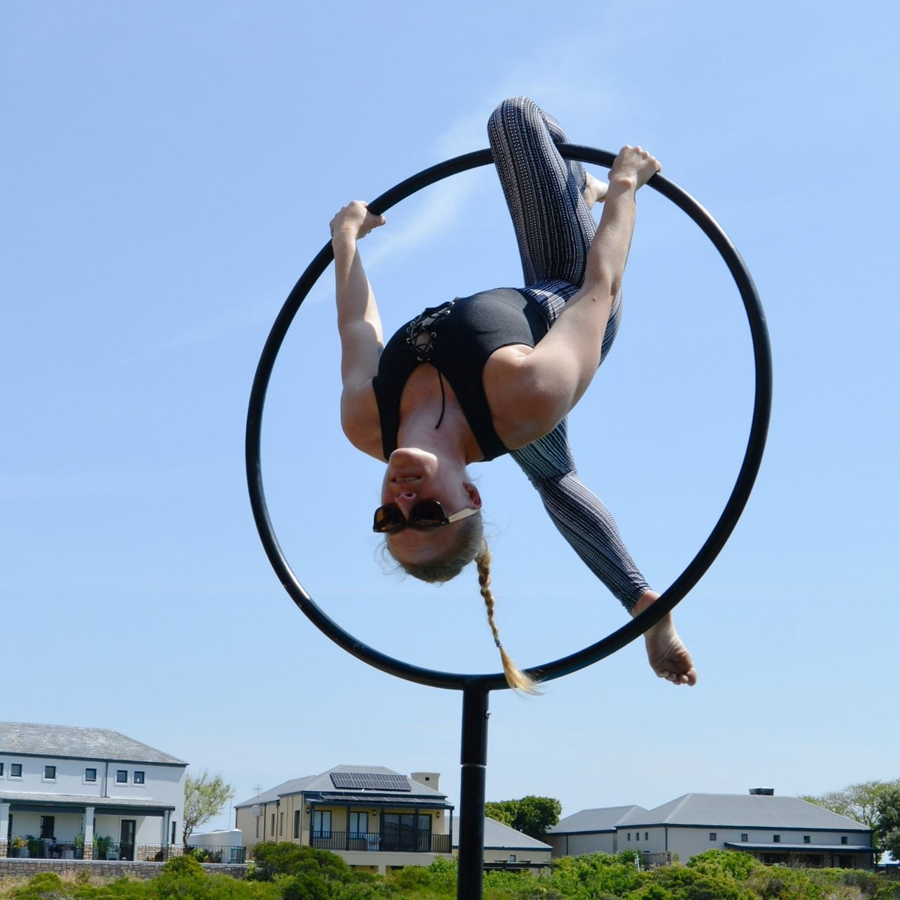 Aerial hoop performance outdoors against a blue sky