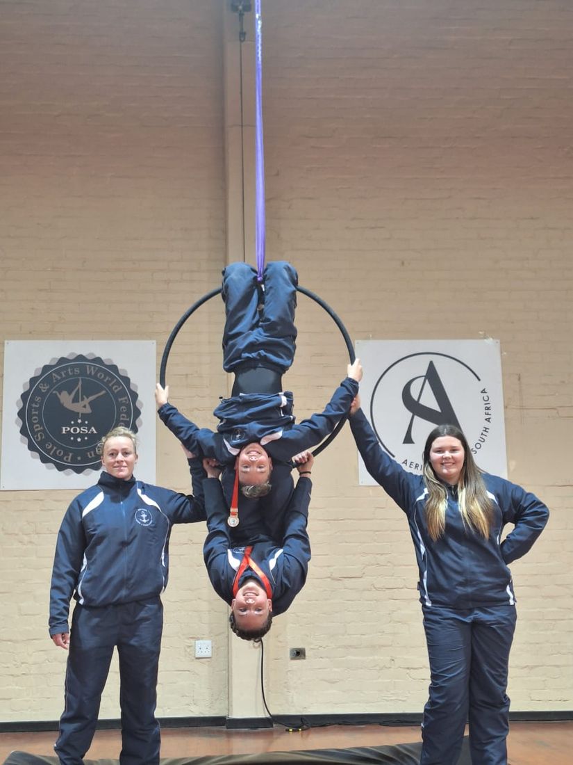 Nautical Aerial team members with a medal at a Pole Sports and Arts competition