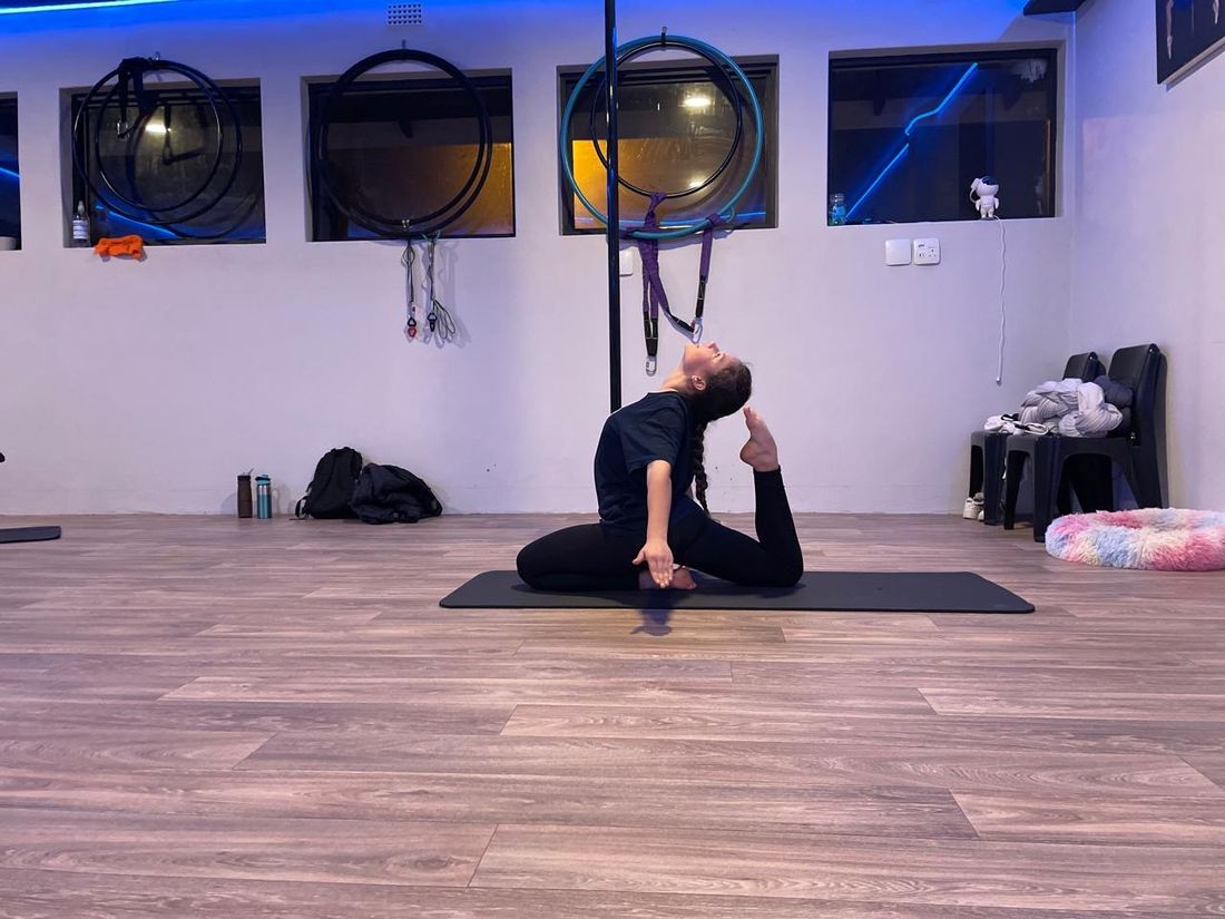 Student holding a seated backbend during an evening flexibility class